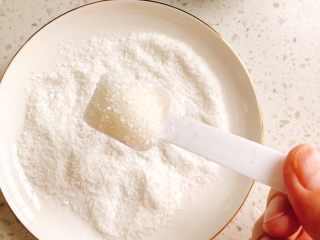 17、这个冬至的汤圆不一样-椰蓉芝士猫爪汤圆,取一个干净的盘子，放入少许椰丝，加入1勺糖，搅拌均匀。