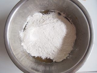 3、蛋黄豆沙月饼,将面粉和奶粉倒入,用筷子稍微搅拌均匀