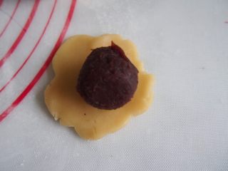 9、蛋黄豆沙月饼,将面团压扁,包上蛋黄豆沙馅