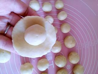 3、苏式鲜肉月饼,将水油皮面团和油酥面团分别分成大小均等的相对等份，我分了14份，并静置松弛15分钟左右。取一个小的水油皮面团，在手掌上压扁。把小油酥面团放在压扁的水油皮面团上。用水油皮面团把油酥面团包起来。