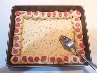 27、香肠苹果披萨,用叉子在面皮底部扎出密集的小孔