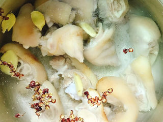 3、花生猪蹄汤,生姜切片放入锅中、放入花椒粒