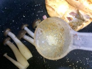 15、海苔鲜味三文鱼,三文鱼放平底锅一边，把碗里的姬菇捞出放入煎三文鱼的锅里，利用余油煎一下姬菇撒上少许调味盐