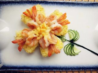 15、奶酪蝴蝶虾饭团,烤好后取出，将沙拉酱或千岛酱装入剪口裱花袋，挤上酱汁，再用黄瓜摆好叶子和花茎即可