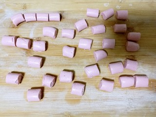 6、酒酿桂花粉红鸡蛋丸子,用刀将细条切成大小相同的小剂子。