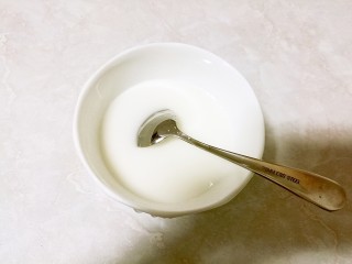 9、酒酿桂花粉红鸡蛋丸子,碗中放入一些玉米淀粉，倒入适量的水搅拌均匀。