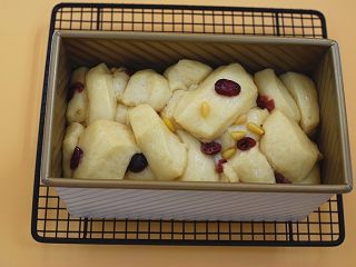 11、日式炼乳吐司,烤盘中再放上一杯开水，启用烤箱发酵档30分钟，剩下利用余温发酵，发至模具的八分高，轻触面团有少许弹性