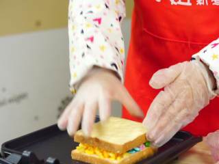 8、彩虹吐司制作图文详细教程, 自己动手做爆款高颜值网红小吃,最后再取另一块吐司，不摸黄油的一面盖上加了芝士的那一块就行了。