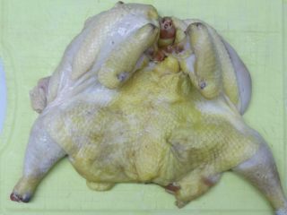 1、烤脆皮鸡,鸡洗净，去头，用剪刀剪开出来，用牙签在表面扎下，这样能腌得更人味，洗好的鸡挂起来晾干水份，晾时间长点，这样能使表面皮干一些