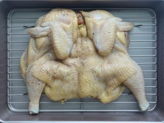 6、烤脆皮鸡,接下来是做脆皮鸡的关键要求，用厨房纸巾把鸡表面擦干，然后放在学厨的长方形烤盘带烤架上