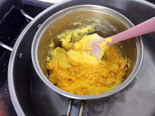 16、金沙奶黄馅(为月饼季而准备),此时面糊中的水分会慢慢收干,有点耐心继续炒,炒到面糊成团时,加入过筛后的咸蛋黄。