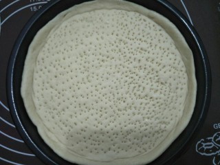 10、咖喱披萨,将面皮放入涂了油的烤盘中,用叉子在面皮上叉出小孔防止面皮在烤的过程鼓起。