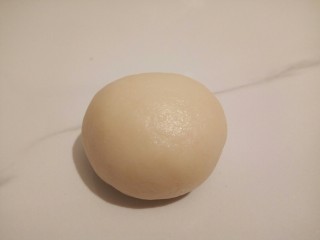 6、#甜味#凤梨蛋黄酥,用虎口收口，揉圆，收口朝下，每包好一个都要用保鲜膜盖好，醒10分钟后.，从第一个包好的开始进行