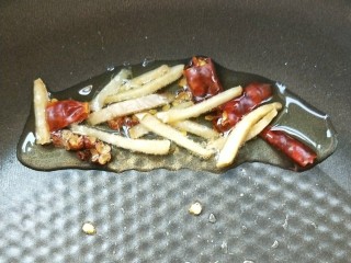 5、豉香腊肠炒蒜苗,起油锅，放干辣椒，红椒粒，姜丝，小火慢慢煸出香辣味。