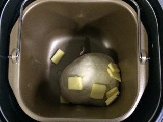 2、培根口蘑田园披萨,揉至10分钟面团成型后，加入黄油继续揉面约10分钟成均匀的面团。