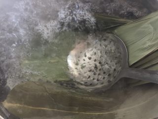 6、肉粽子,锅里烧一锅水，水开后轻轻的放入粽叶，继续煮3-5分钟，关火，让粽叶完全被水盖住，浸泡20分钟
