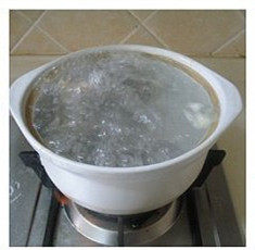 2、教你如何在家做一碗高颜值的［海鲜乌冬面］,将煮开并变色的牛尾捞出放在旁边已煮开的砂锅里，再把砂锅里浮沫捞出。