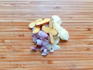 1、#吃鸡#日式咖喱鸡腿饭,大蒜、红葱头和生姜切片备用,把米饭先煮上