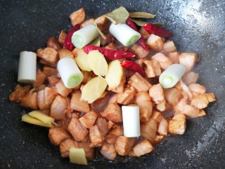 6、啤酒红烧肉,下入葱段、姜片、八角、香叶和干红辣椒。