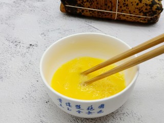 3、酥香碱水粽,用筷子顺着一个方向把鸡蛋打散。