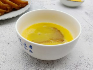 6、酥香碱水粽,碱水粽在鸡蛋液中过一下，让其沾满蛋液。