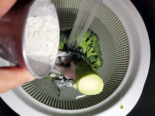 5、蒜蓉西兰花,西兰花放入洗菜盆中,花顶朝下,倒入面粉