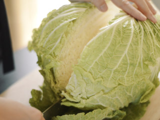 1、制作自家口味的韩式泡菜,大白菜从中间切成两半。