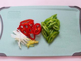 7、藕片爆桃花蛸,再用刀把青红椒切丝，葱姜切丝备用。