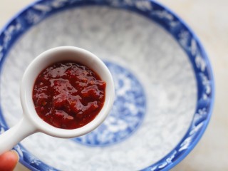 2、好吃到舔盘的韩式辣酱炒年糕,大碗中加两勺辣椒酱。