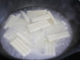 8、好吃到舔盘的韩式辣酱炒年糕,锅中烧开水加入年糕煮熟。