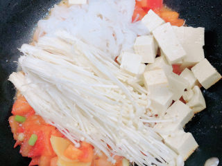 10、砂锅鱼头煲,将魔芋粉、金针菇、豆腐都放入锅中。