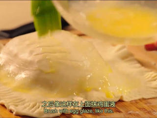 9、起酥三文鱼派,在派的表面划一些刀口，在鱼派的表面均匀涂抹上蛋液，放在涂抹橄榄油的烤盘上，接着放进200度的烤箱烤30-35分钟即可