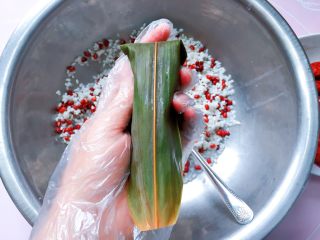 11、红豆红枣粽,如图把粽叶折过去，盖住糯米；