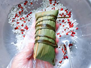 12、红豆红枣粽,再把粽叶折回来收口，最后用粽绳绑好打结。