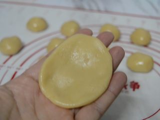 11、豆沙蛋黄月饼,取一块饼皮放手心按扁