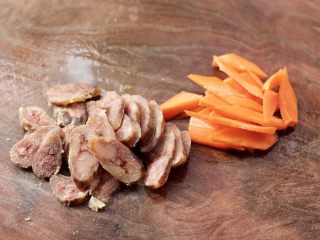 3、腊肠炒鸡蛋,胡萝卜用刀切成菱形片，腊肠斜切成薄片。