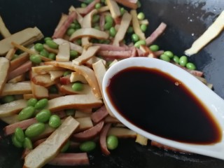 12、毛豆炒香干,放入一汤匙生抽增鲜。