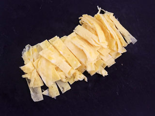 6、白玉菇炒鸡蛋,把鸡蛋饼切成小条