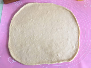 6、大虾披萨,将面团取出擀成和披萨盘大小的圆形。