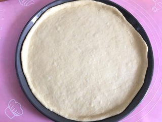 8、大虾披萨,用手指将饼皮四周按开。