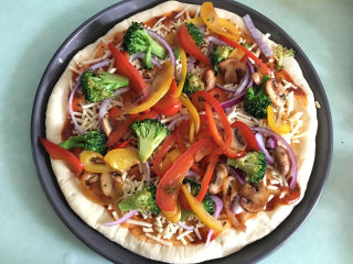 13、大虾披萨,将去水的蔬菜均匀的摆在芝士碎上。