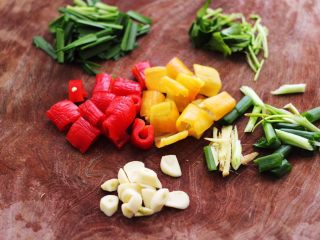 2、双椒烩双色豆腐,红椒和黄椒用刀切成块,韭菜和香菜切段,葱姜切丝,大蒜切成薄片。