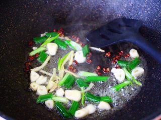 6、双椒烩双色豆腐,锅烧热后,倒入花生油烧至六成热时,小火炸香花椒后,再爆香葱姜蒜。