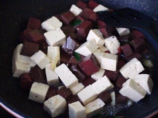 8、双椒烩双色豆腐,再加入焯过水的豆腐,大火翻炒片刻。