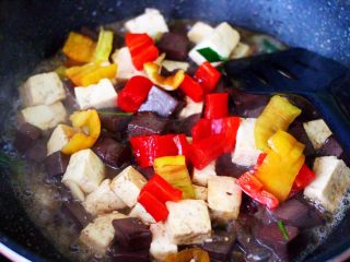 14、双椒烩双色豆腐,这个时候加入切块的红椒和黄椒,大火翻炒片刻。