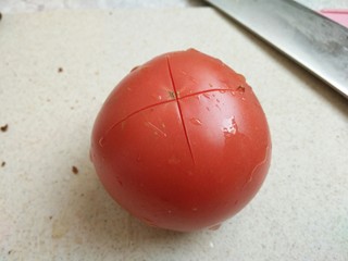 9、茄汁牛肉穿肠意面,准备一个西红柿洗干净切十字花刀