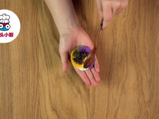 5、自制彩色琉璃汤圆,将小剂子按扁，包入内馅，收口搓圆