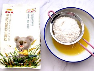 4、核桃酥,碗中再筛入称重后的面粉和泡打粉。