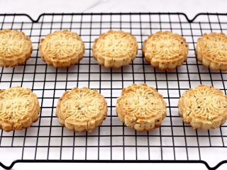 13、核桃酥,香酥可口的核桃酥出炉咯,戴上隔热手套取出烤盘,放到架子上面放凉即可食用咯。