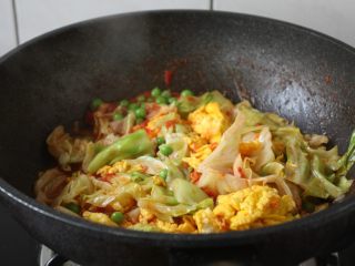 14、番茄鹅蛋炒豌豆卷心菜,放入炒好的鹅蛋，翻炒均匀。